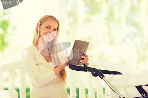 Image of happy mother with tablet pc and stroller in park