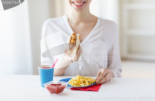 Image of close up of woman eating hotdog and french fries