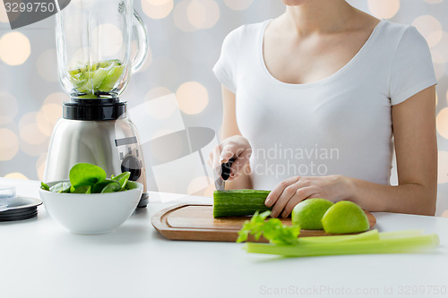 Image of close up of woman with blender chopping vegetables