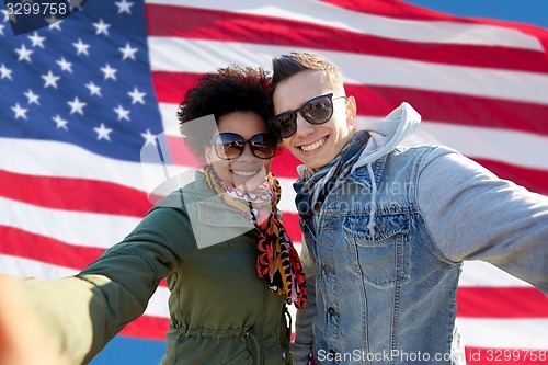 Image of happy couple taking selfie over american flag