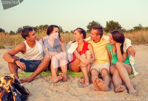 Image of smiling friends in sunglasses on summer beach