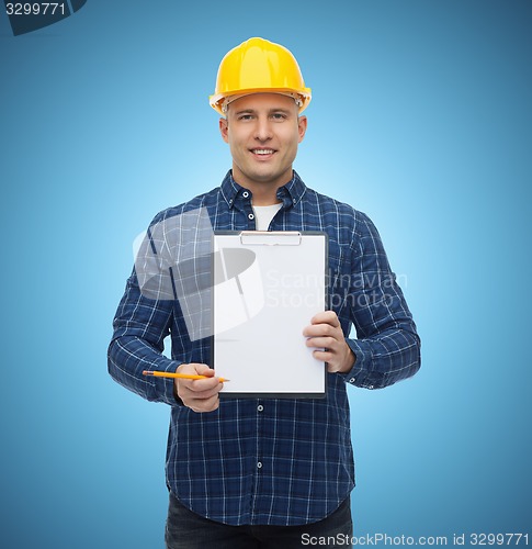 Image of smiling male builder in helmet with clipboard