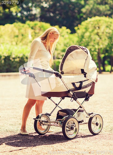 Image of happy mother with stroller in park