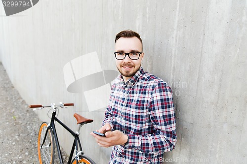 Image of hipster man in earphones with smartphone and bike