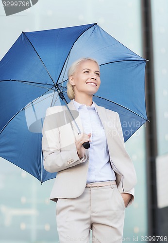 Image of young smiling businesswoman with umbrella outdoors