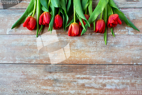 Image of close up of red tulips on wooden background