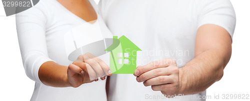 Image of couple hands holding green house