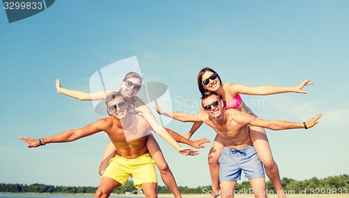 Image of smiling friends having fun on summer beach