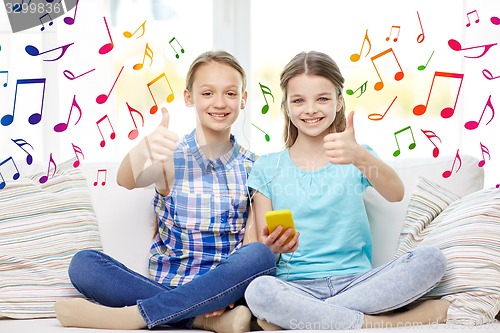 Image of happy girls with smartphone sitting on sofa