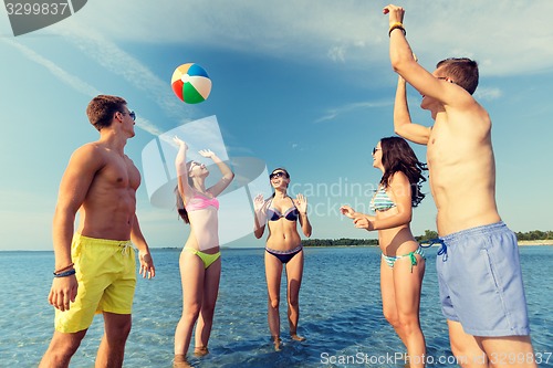 Image of smiling friends in sunglasses on summer beach