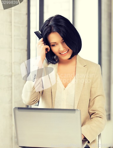 Image of happy woman with laptop computer and credit card