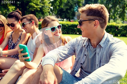 Image of smiling friends with smartphone making selfie