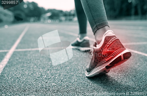 Image of close up of feet with red spot running on track