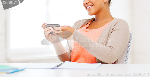 Image of african woman with smartphone in office