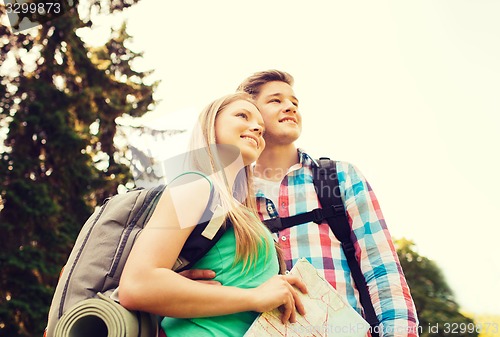 Image of smiling couple with map and backpack in nature