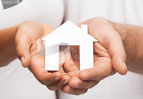 Image of couple hands with paper house