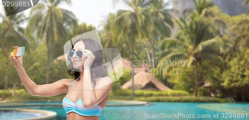 Image of woman in swimsuit taking selfie with smatphone