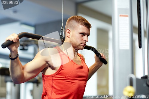 Image of man flexing muscles on cable machine gym