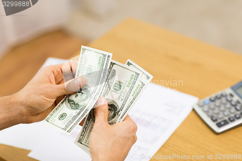 Image of close up of man hands counting money at home