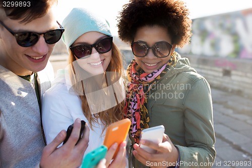 Image of smiling friends with smartphones