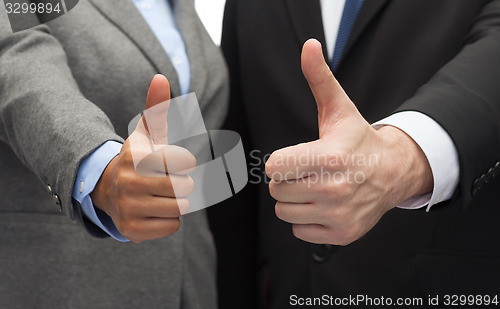 Image of businessman and businesswoman showing thumbs up