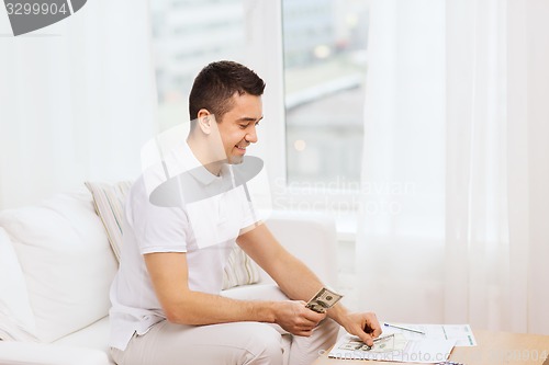 Image of man with papers and calculator at home