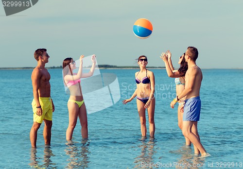 Image of smiling friends in sunglasses on summer beach