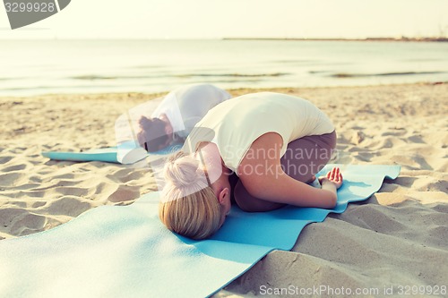 Image of close up of couple making yoga exercises outdoors
