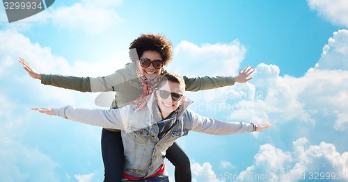 Image of happy teenage couple in shades having fun outdoors