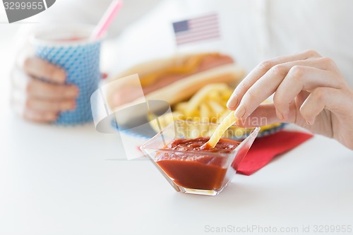 Image of close up of woman hands eating on american food
