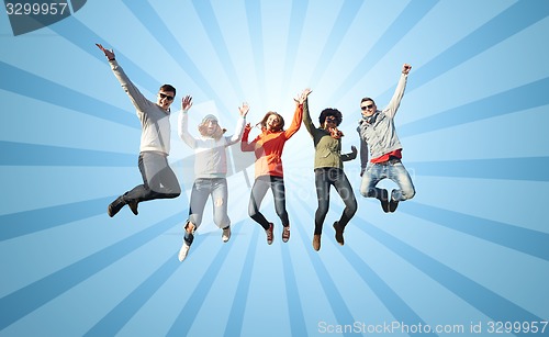 Image of smiling friends in sunglasses jumping high