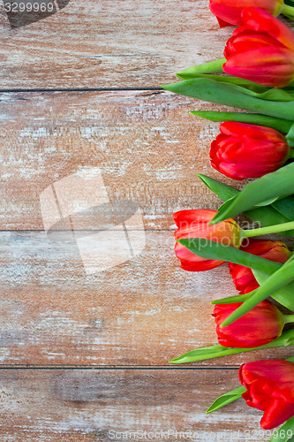 Image of close up of red tulips on wooden background