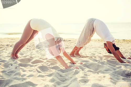 Image of couple making yoga exercises outdoors