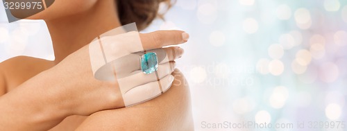 Image of close up of woman with cocktail ring on hand