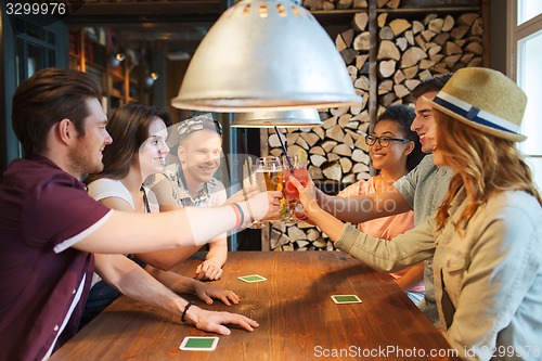 Image of happy friends drinking beer at bar or pub