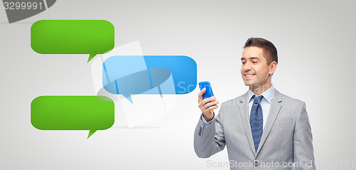 Image of happy businessman texting message on smartphone