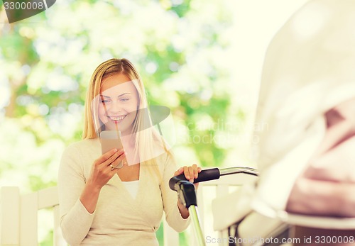 Image of happy mother with smartphone and stroller in park