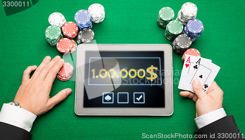 Image of casino poker player with cards, tablet and chips