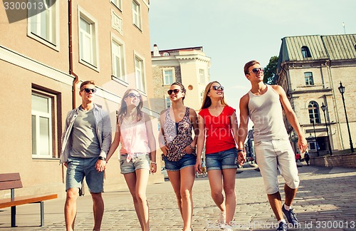 Image of group of smiling friends walking in city