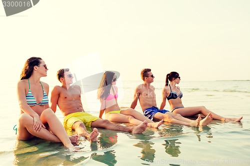 Image of smiling friends in sunglasses on summer beach