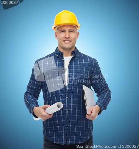 Image of smiling male builder in helmet with blueprint