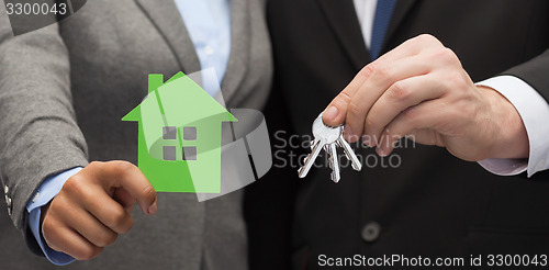 Image of businessman and businesswoman holding green house