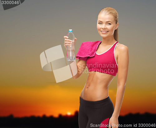 Image of happy woman with water bottle and towel outdoors