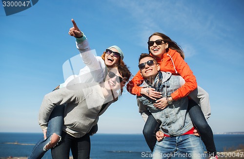 Image of happy friends in shades having fun outdoors