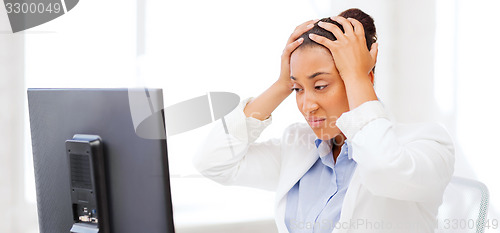 Image of stressed african woman with computer