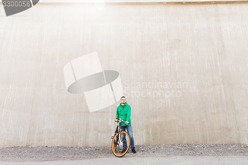 Image of happy young hipster man with fixed gear bike