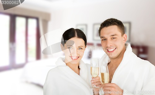 Image of happy couple in bathrobes over spa hotel room