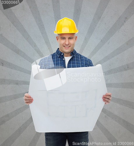 Image of smiling male builder in helmet with blueprint