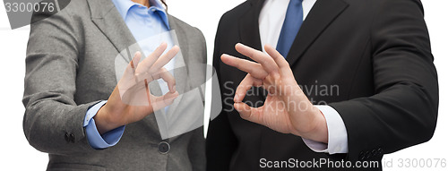 Image of businessman and businesswoman showing ok sign