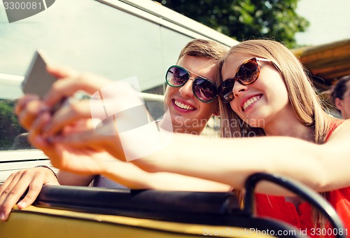 Image of smiling couple with smartphone making selfie